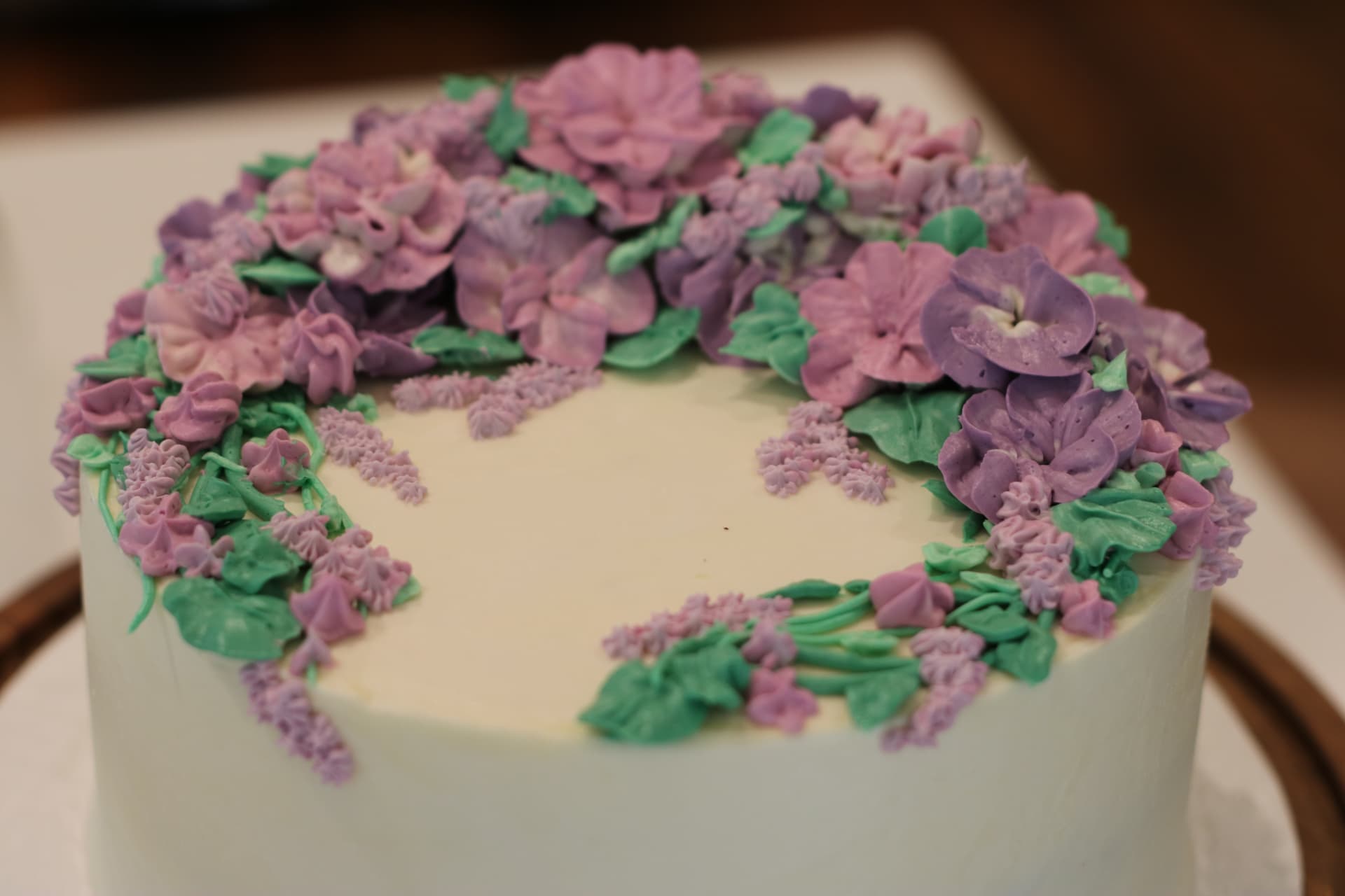 White buttercream cake decorated with lavender and pink piped florals